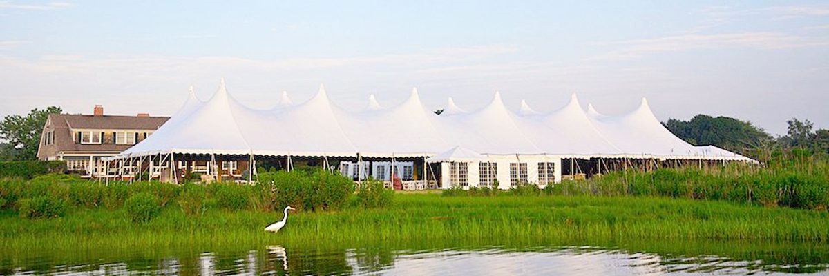 A large white tent in the middle of a field.
